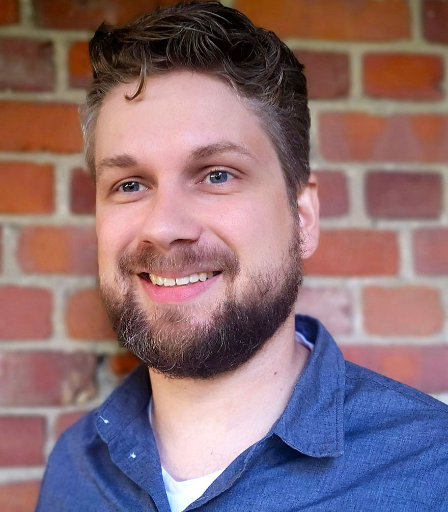 En mann som smiler til kameraet