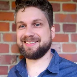 En mann som smiler til kameraet