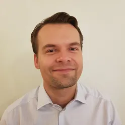 En mann som smiler til kameraet