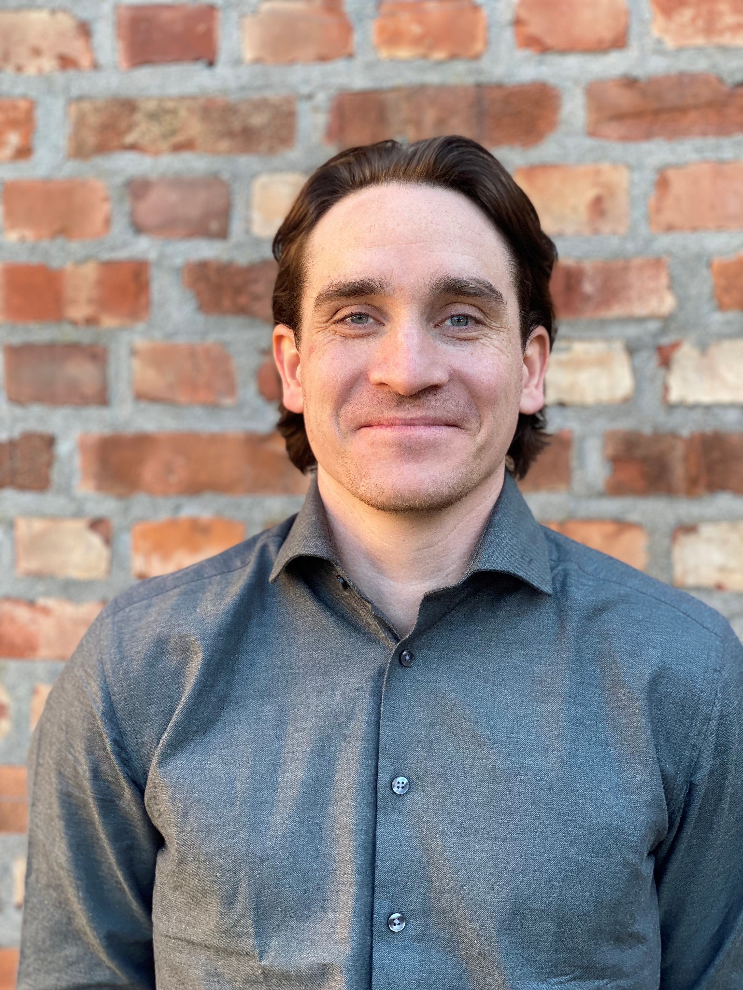 En mann som smiler til kameraet