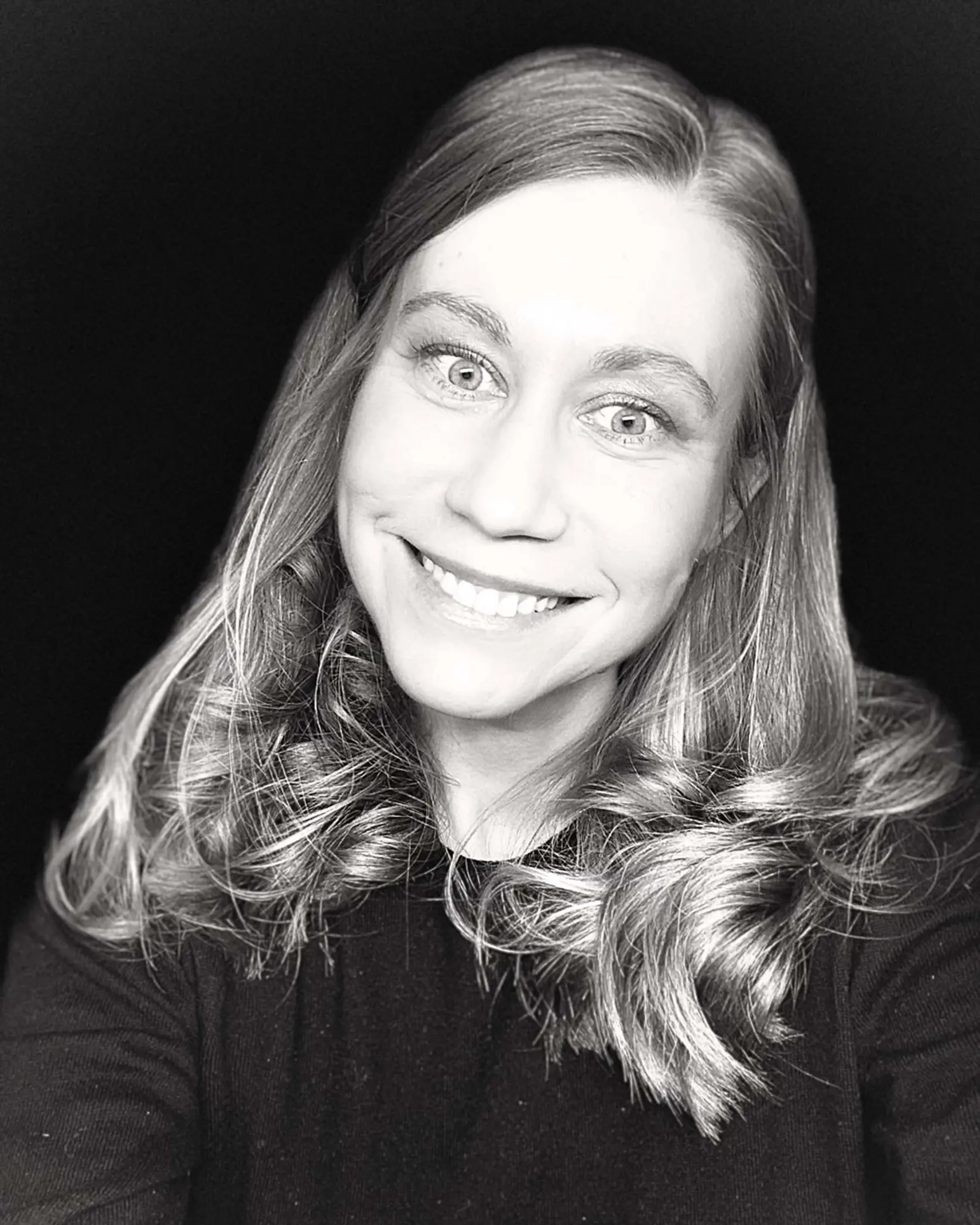 En kvinne med langt hår smilende