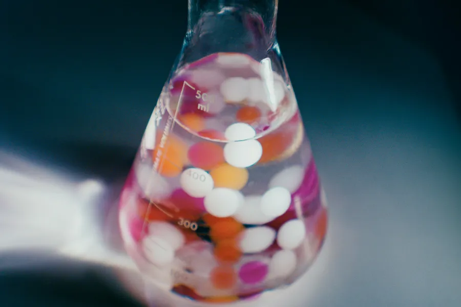 En glassflaske med fargerike godteri