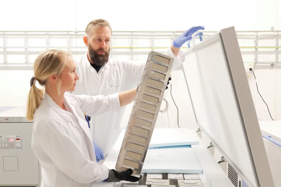 To bioingeniører som løfter et rack opp fra en ultrafryser