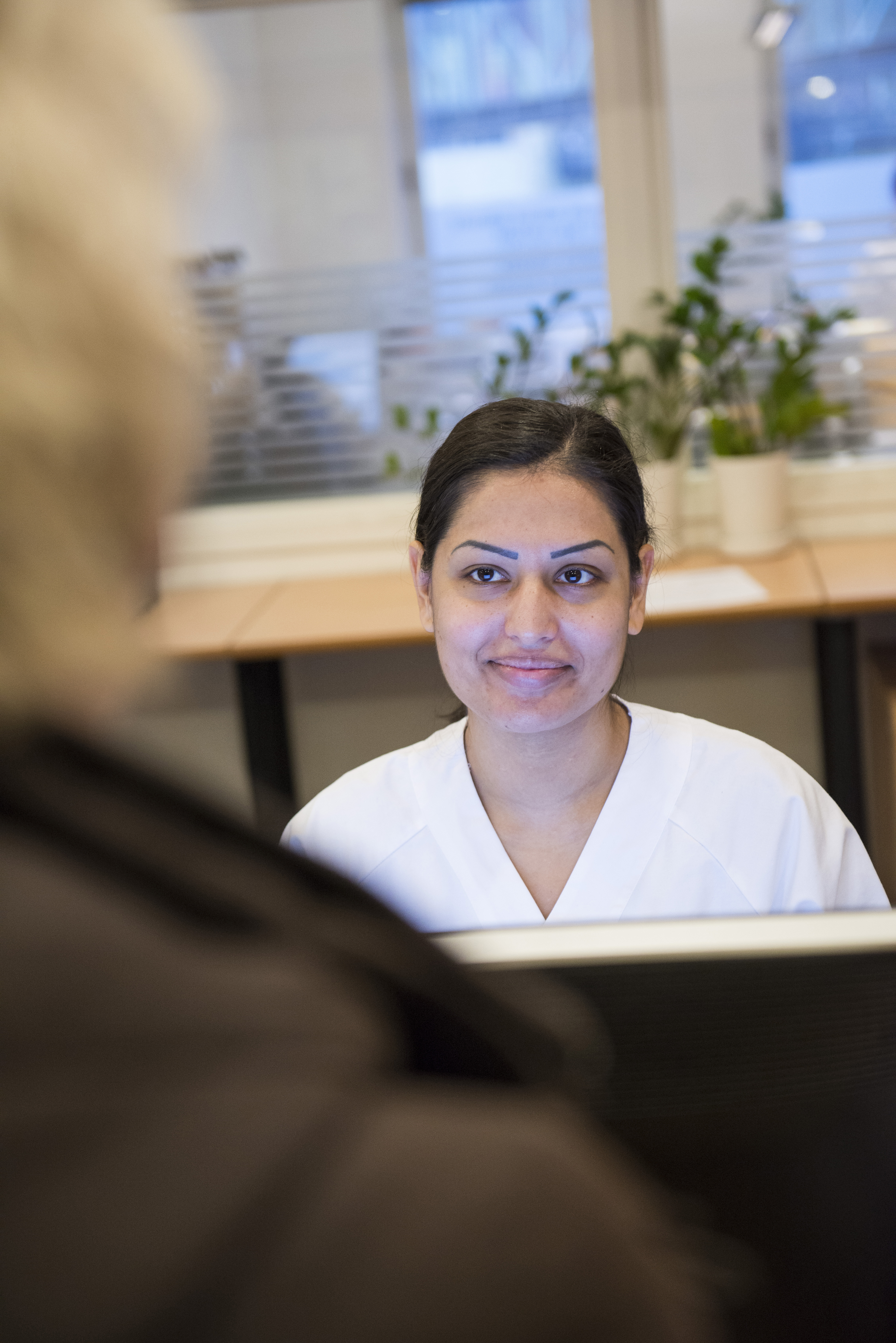 Kvinne i hvitt sykehustøy i resepsjon