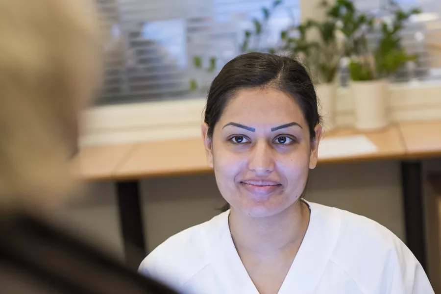 Kvinne i hvitt sykehustøy i resepsjon