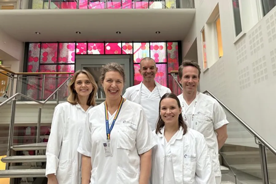 En gruppe mennesker iført hvite laboratoriefrakker og merke