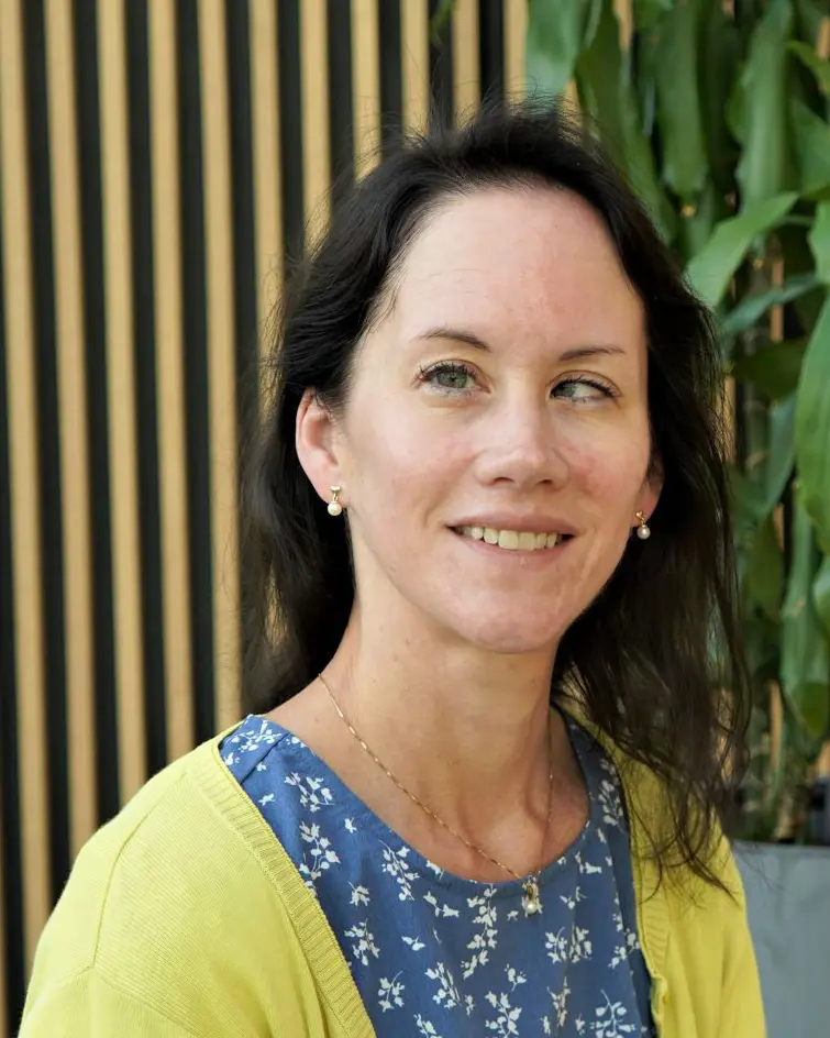 En kvinne som smiler til kameraet