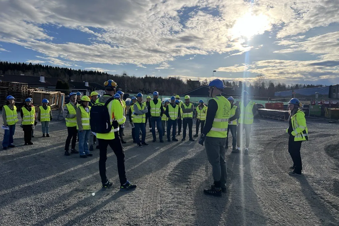 En gruppe mennesker i gule vester som står på en vei