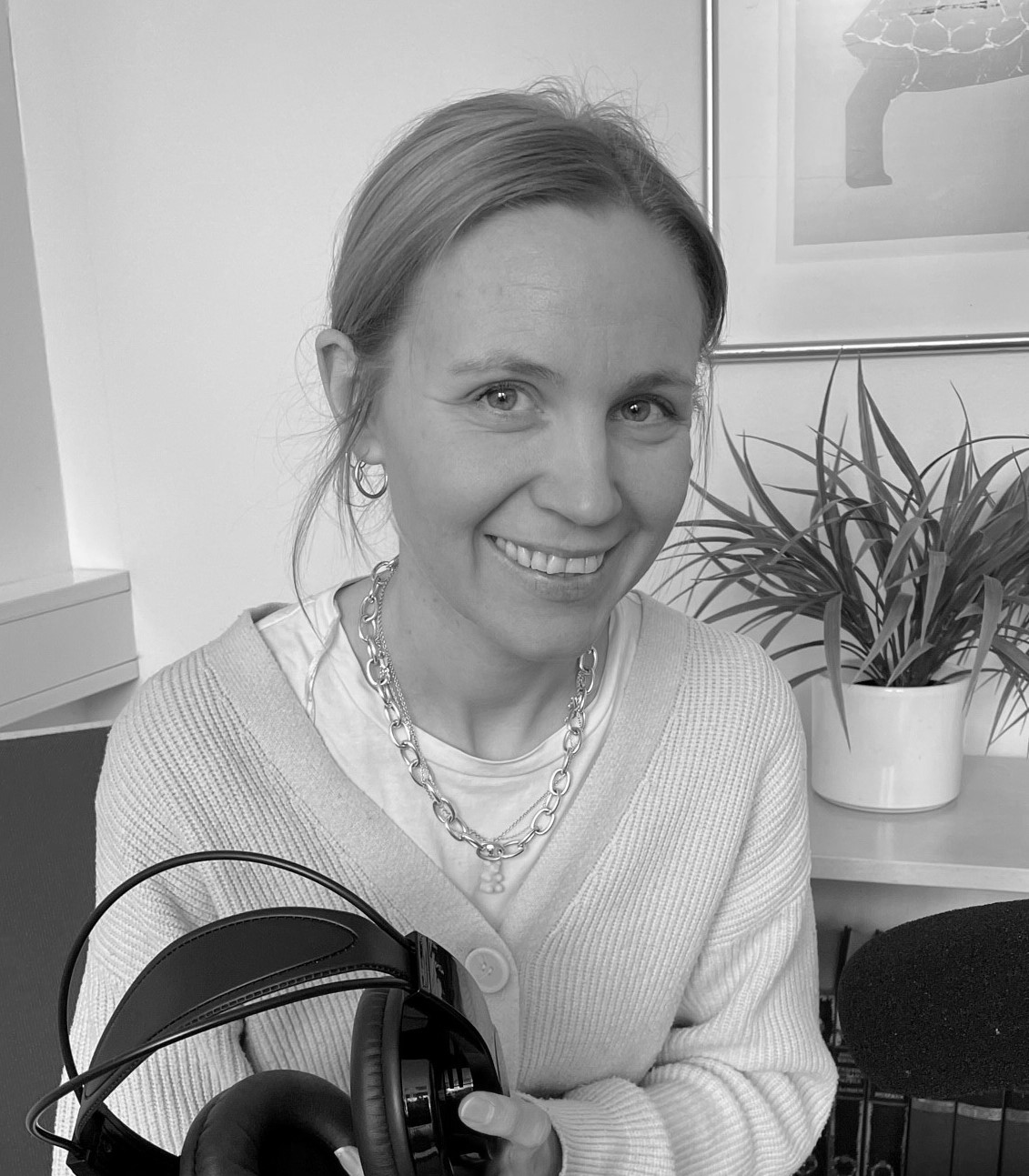 En kvinne som smiler mens hun holder en pistol