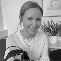 En kvinne som smiler mens hun holder en pistol