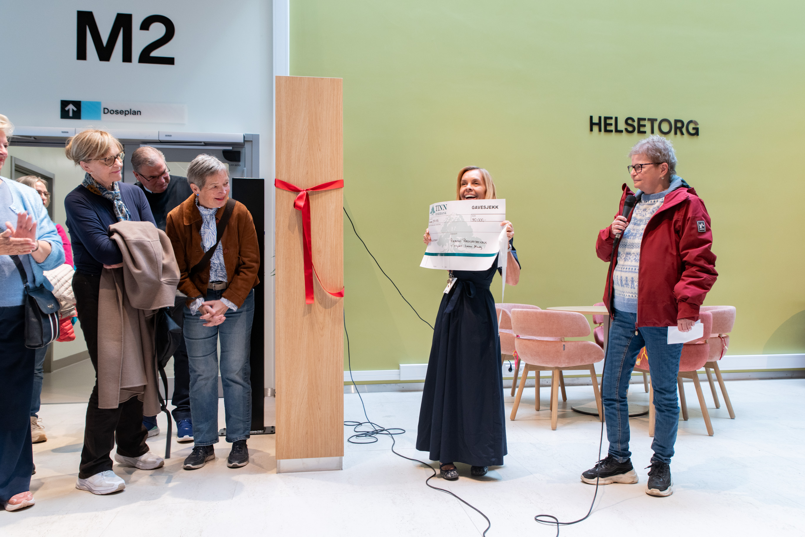 En gruppe mennesker står foran en grønn skjerm