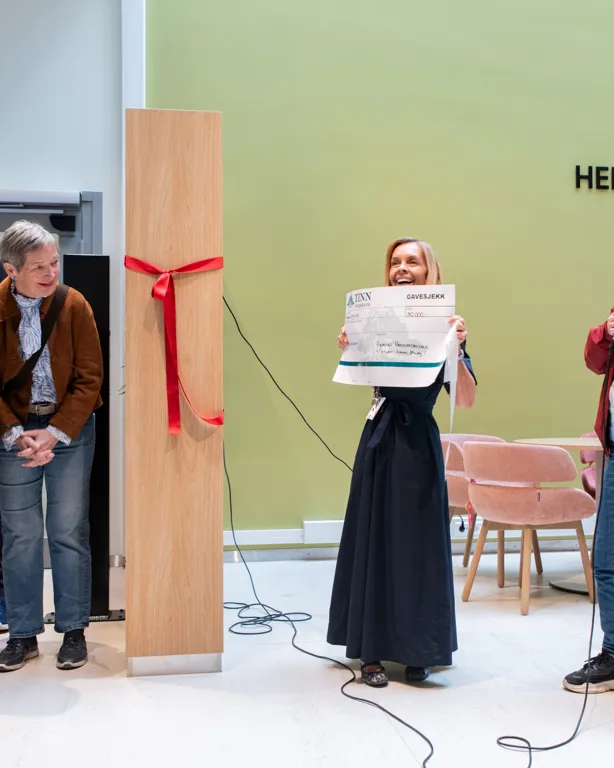 En gruppe mennesker står foran en grønn skjerm