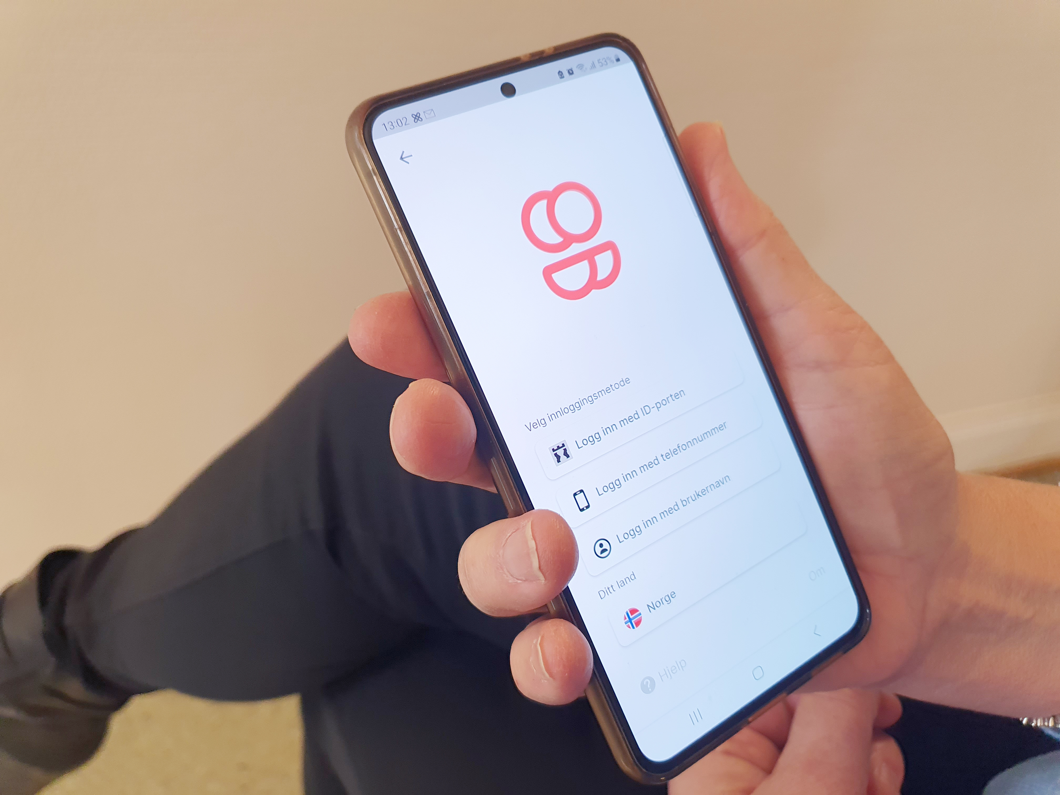 En hånd som holder en mobiltelefon med MyDignio-appen åpen