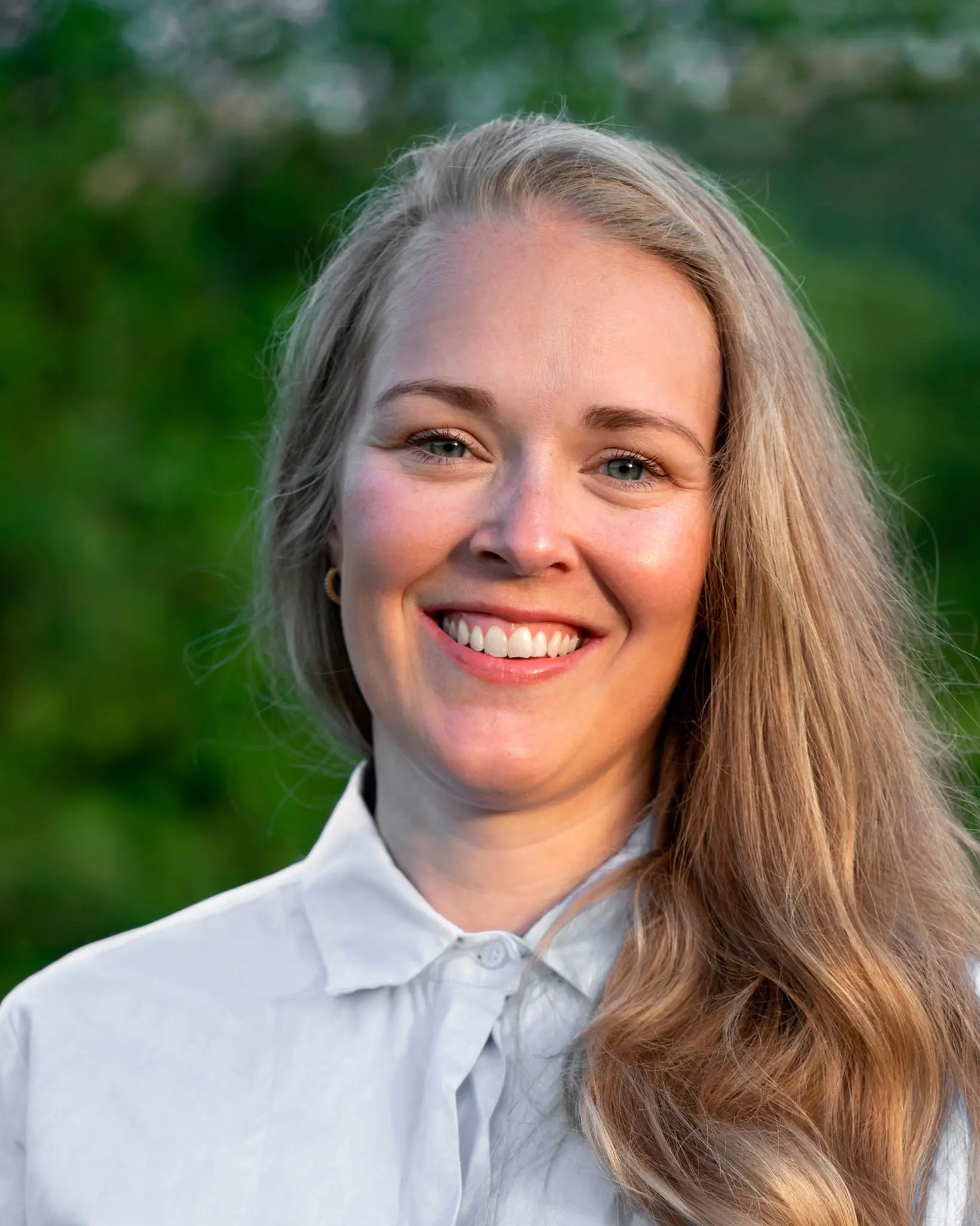 En kvinne som smiler til kameraet