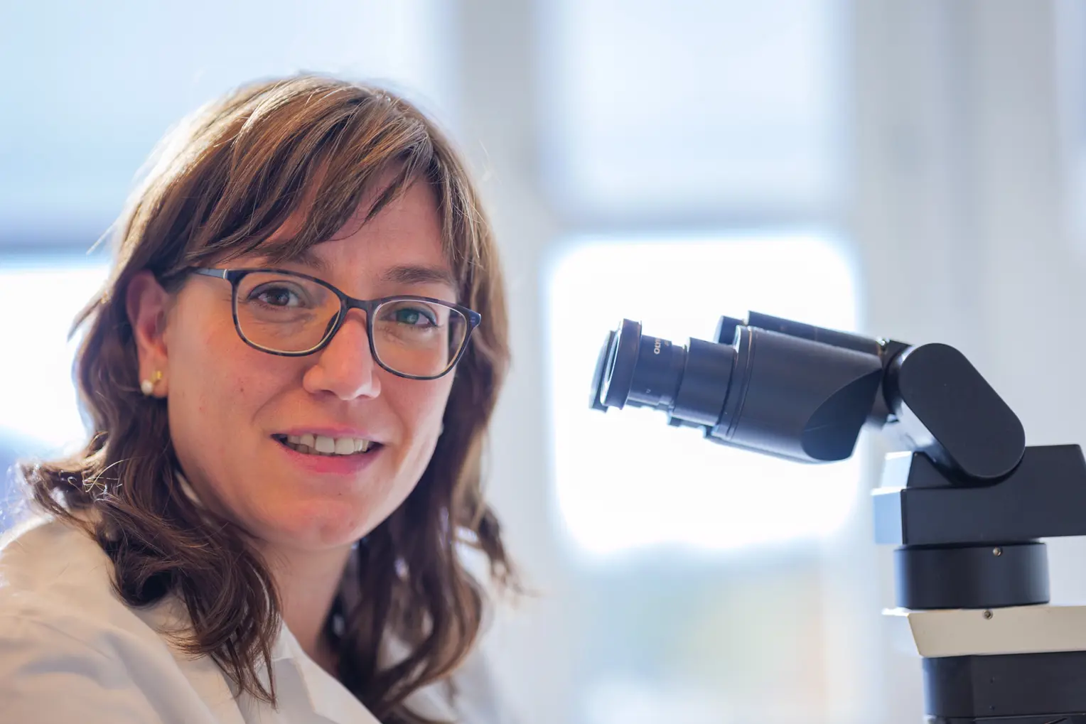 En kvinne som smiler ved siden av en mikrofon