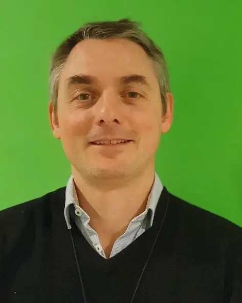 En mann som smiler til kameraet