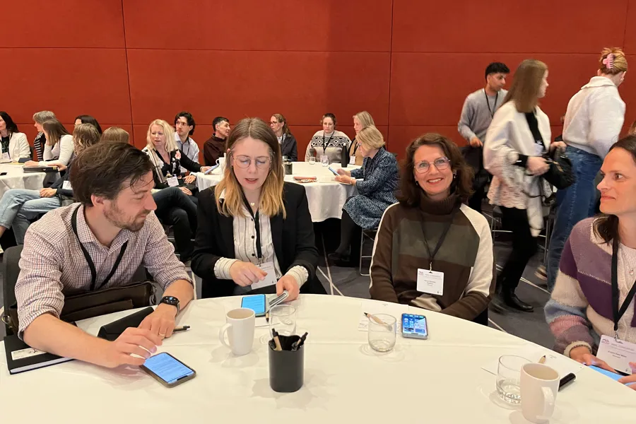 En gruppe mennesker som sitter ved bord