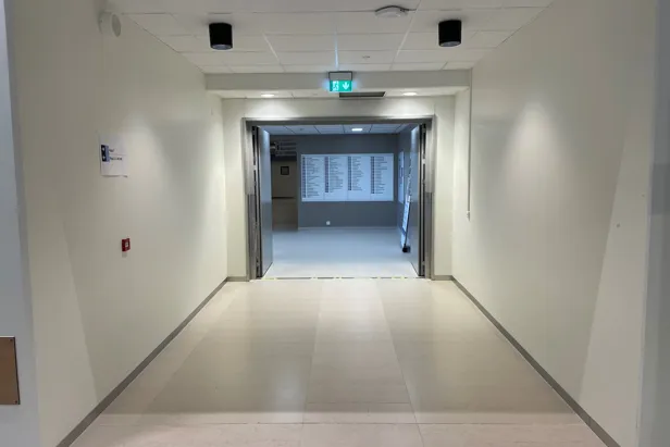 En gang med et skilt på veggen