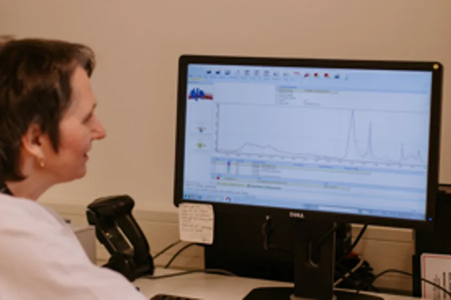 En person som sitter ved et skrivebord og ser på en dataskjerm