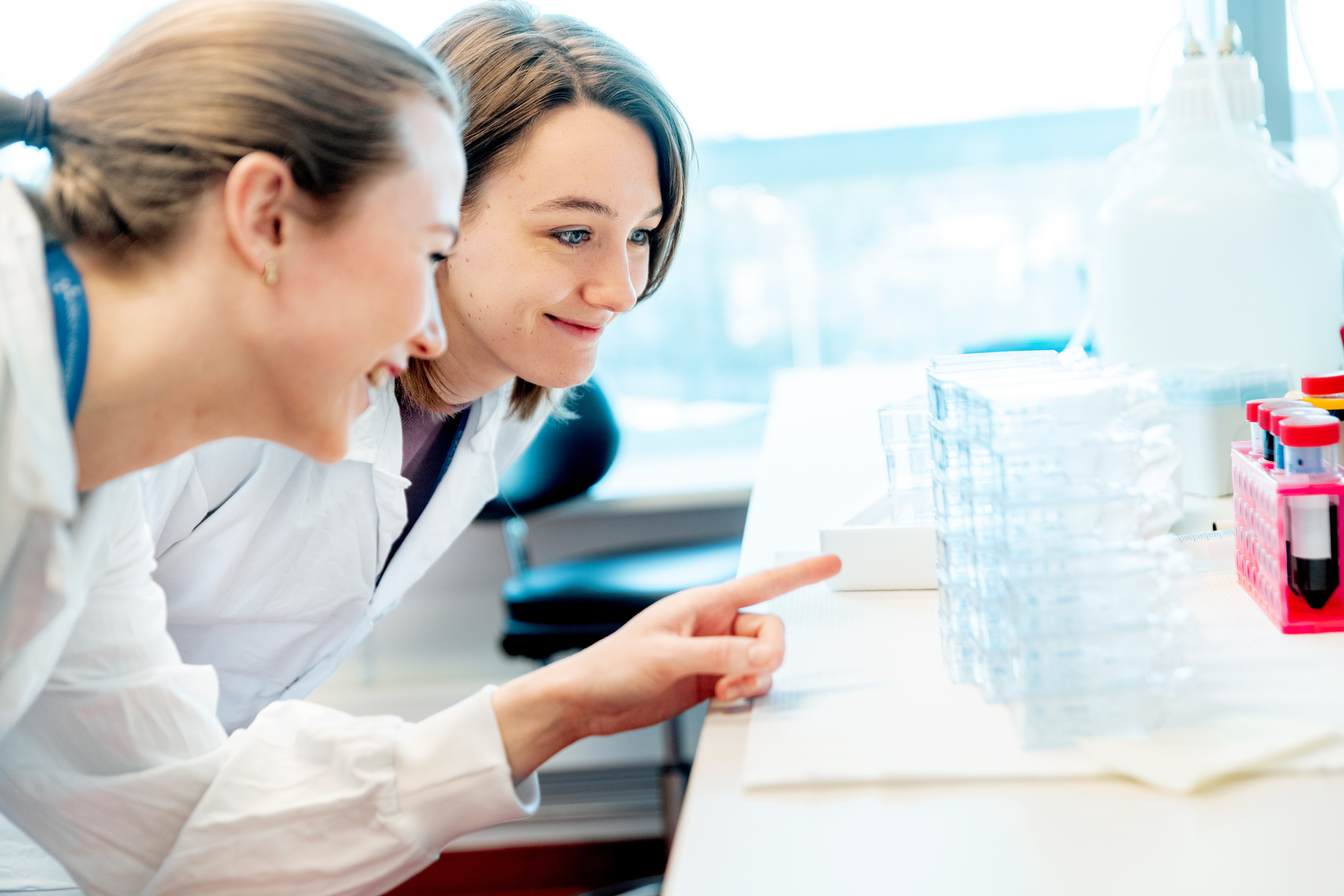 Two hospital employees looking at a test in a lab.