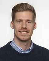 En mann som smiler til kameraet