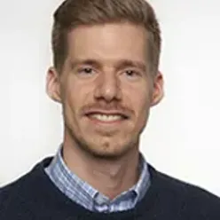 En mann som smiler til kameraet