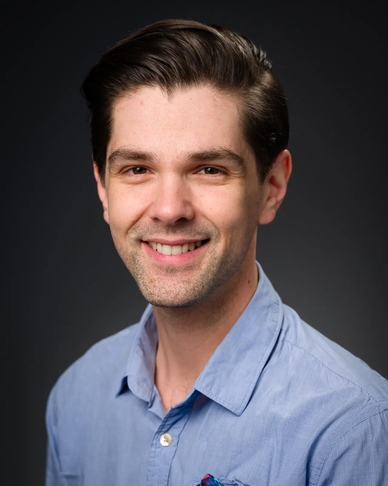 En mann som smiler til kameraet