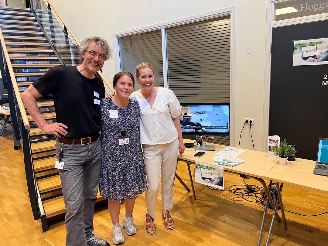 En gruppe mennesker som poserer for et bilde foran et skrivebord