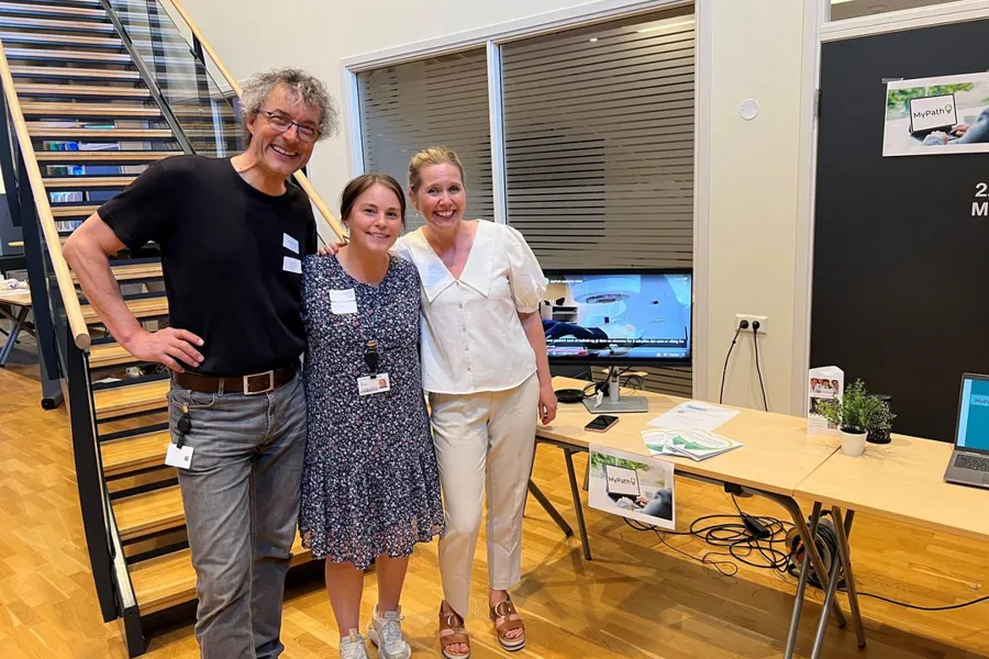 En gruppe mennesker som poserer for et bilde foran et skrivebord