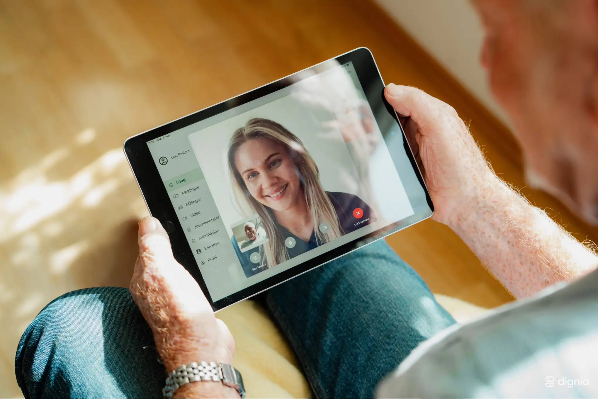 Bilde av pasient som holder ipad og snakker med sykepleier