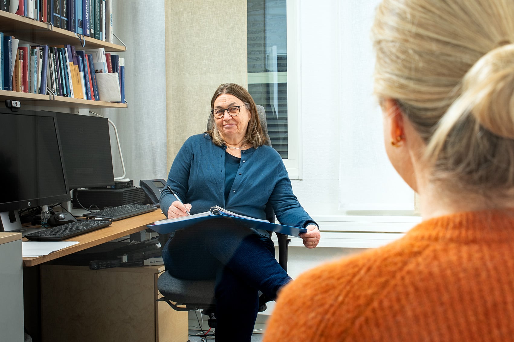 En kvinne som snakker til en gruppe mennesker på et kontor