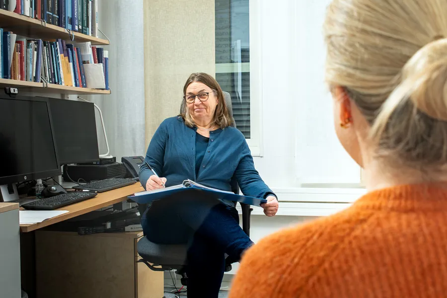 En kvinne som snakker til en gruppe mennesker på et kontor