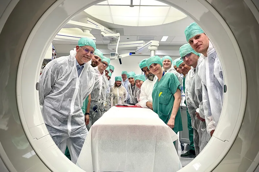 En gruppe mennesker i kirurgiske skrubber og masker som står i et rom