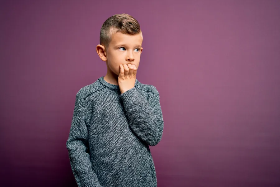 En gutt med hånden på haken