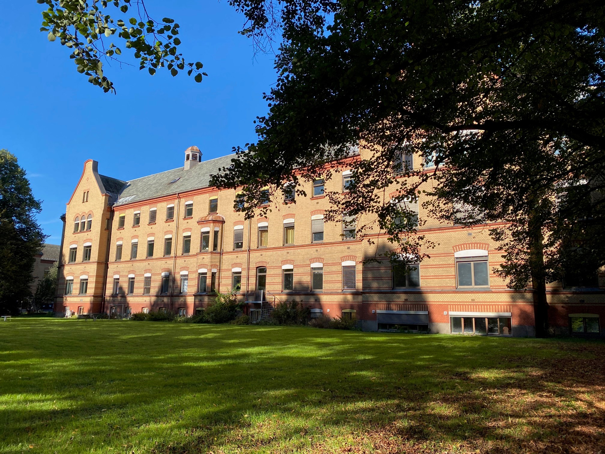 A large brick building with a lawn in front of it