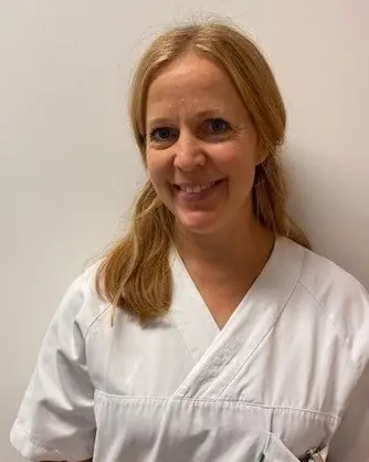 En kvinne som smiler til kameraet