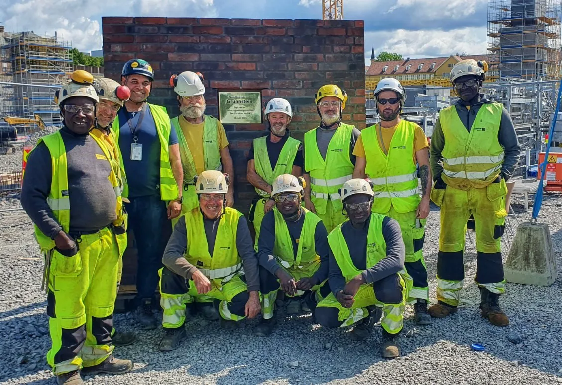 Arbeidere på byggeplassen i arbeidstøy