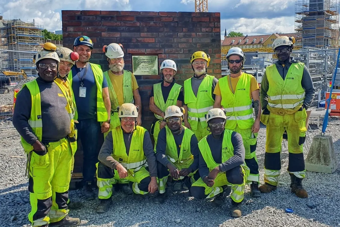 Arbeidere på byggeplassen i arbeidstøy