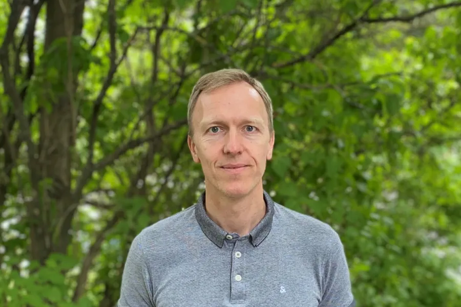 A man standing in front of trees