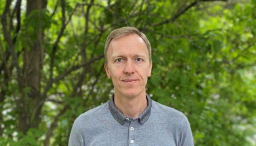 A man standing in front of trees