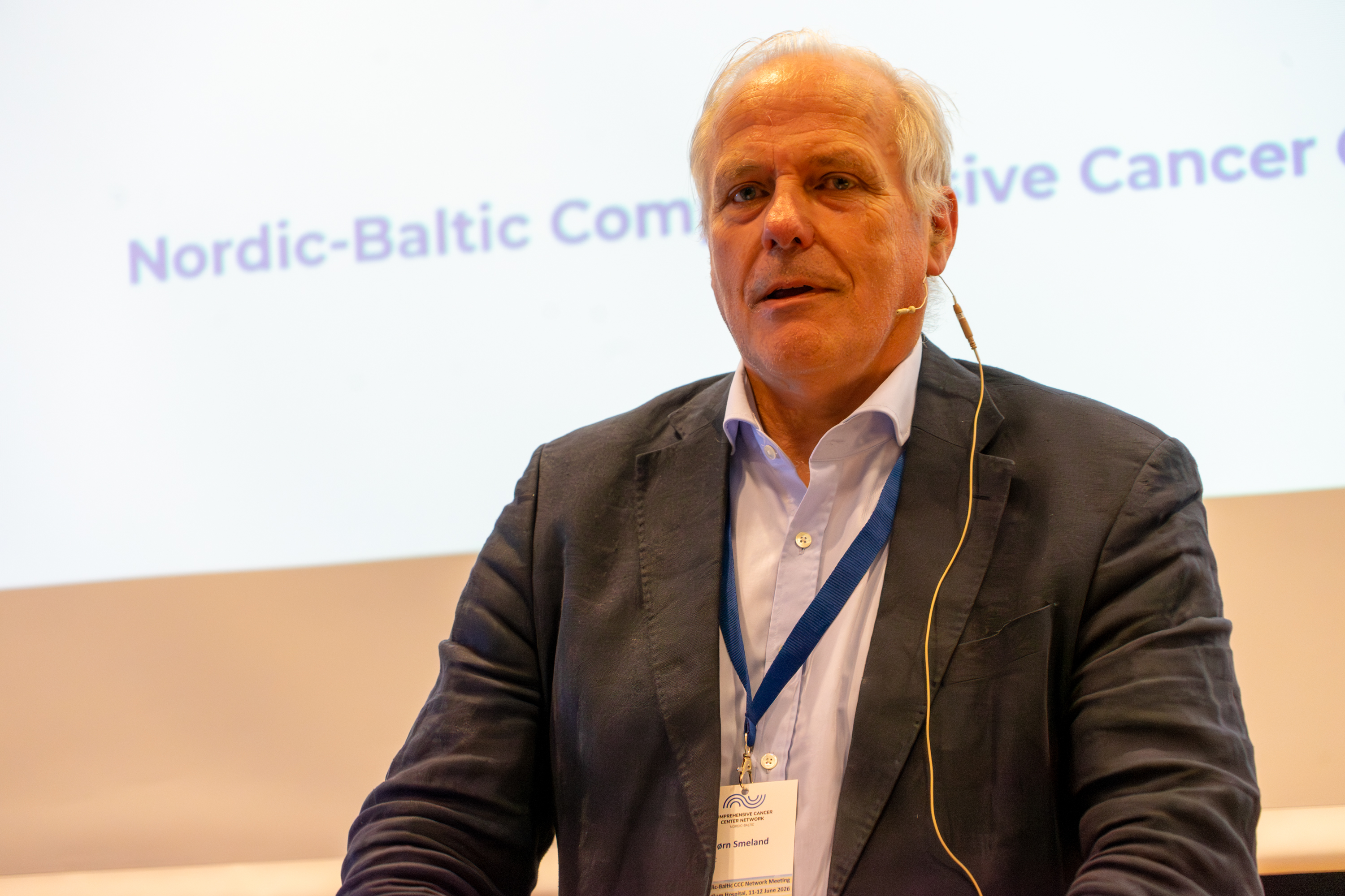 Sigbjørn Smeland står foran en skjerm og snakker.