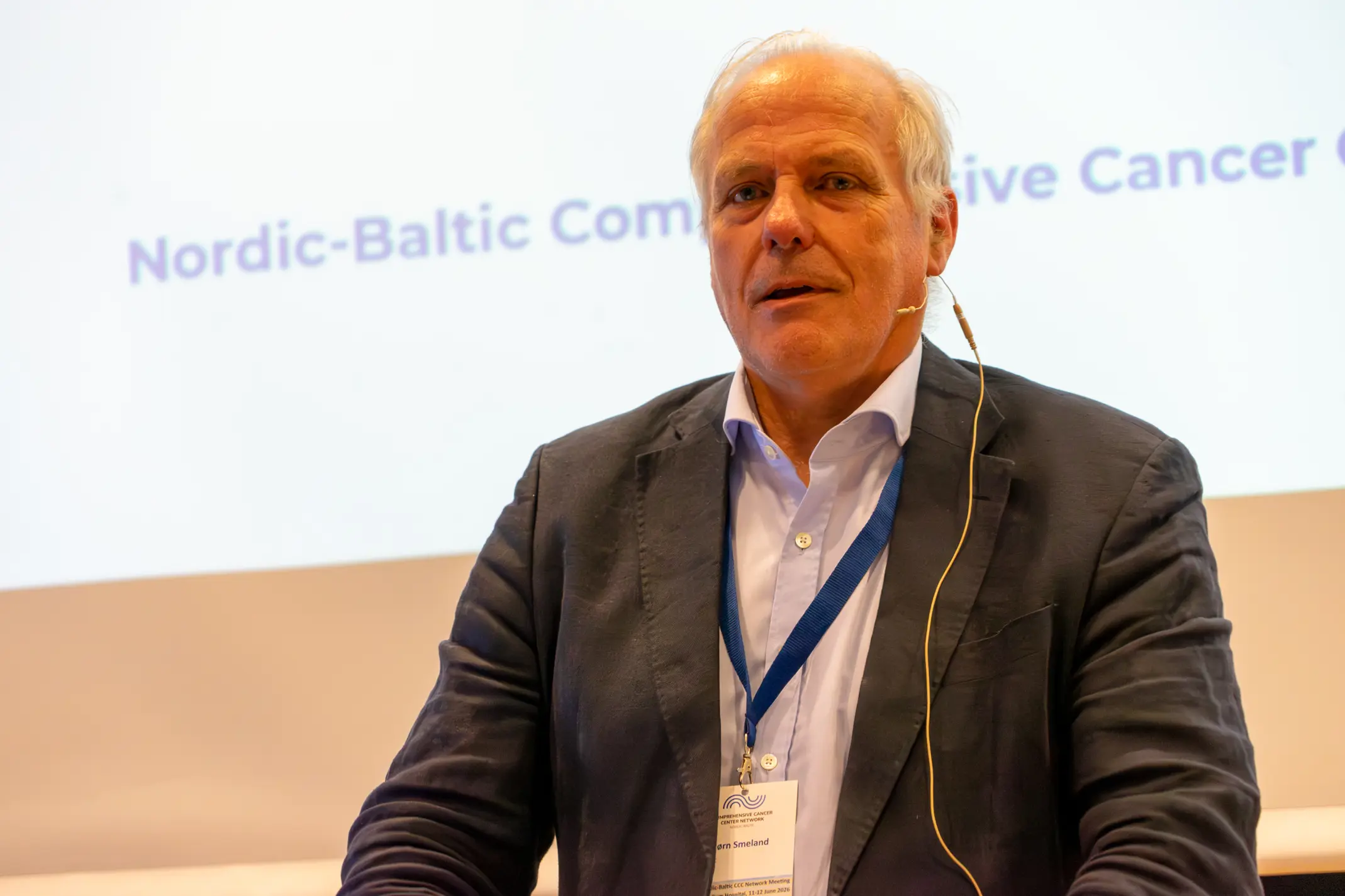 Sigbjørn Smeland står foran en skjerm og snakker.