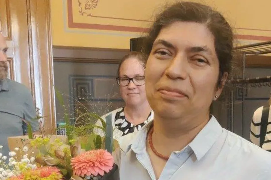 Antonia Villagran med blomster og doktorgradsavhandling