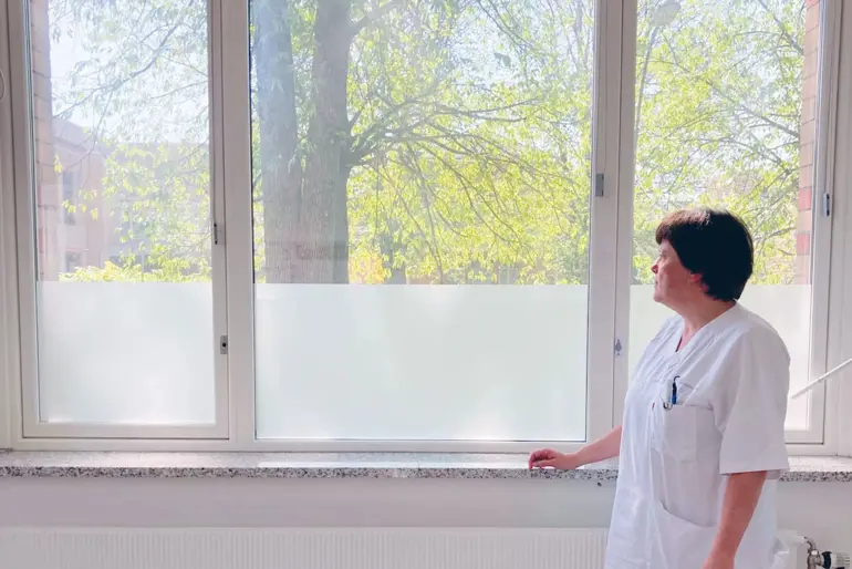 En mann som står foran et vindu