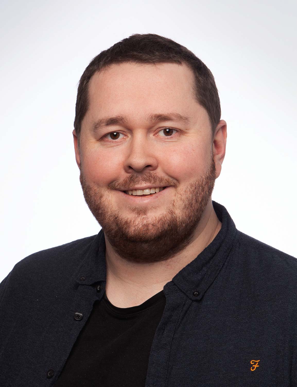 En mann som smiler til kameraet