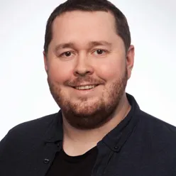 En mann som smiler til kameraet