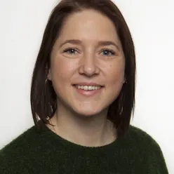 En kvinne som smiler til kameraet