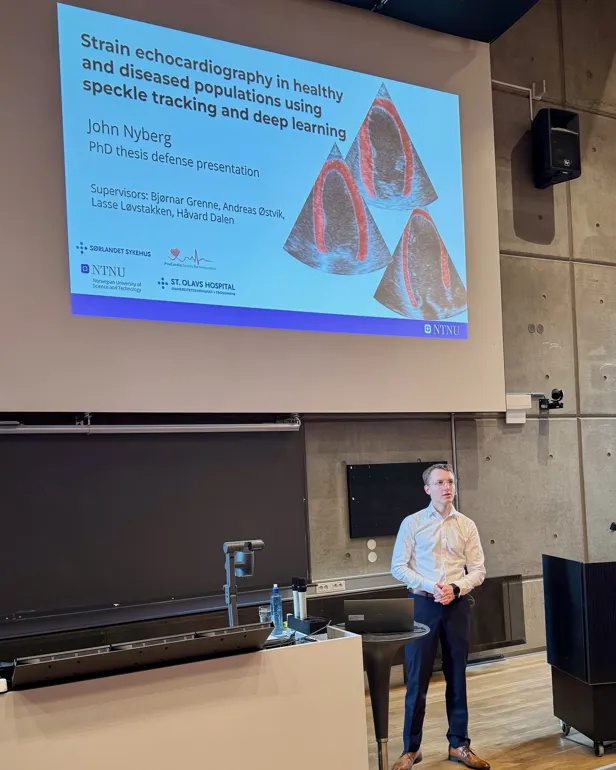 A man standing in front of a projector screen