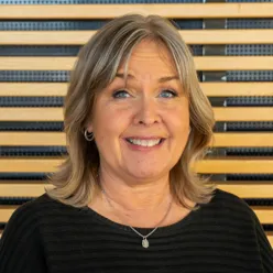 En kvinne som smiler til kameraet