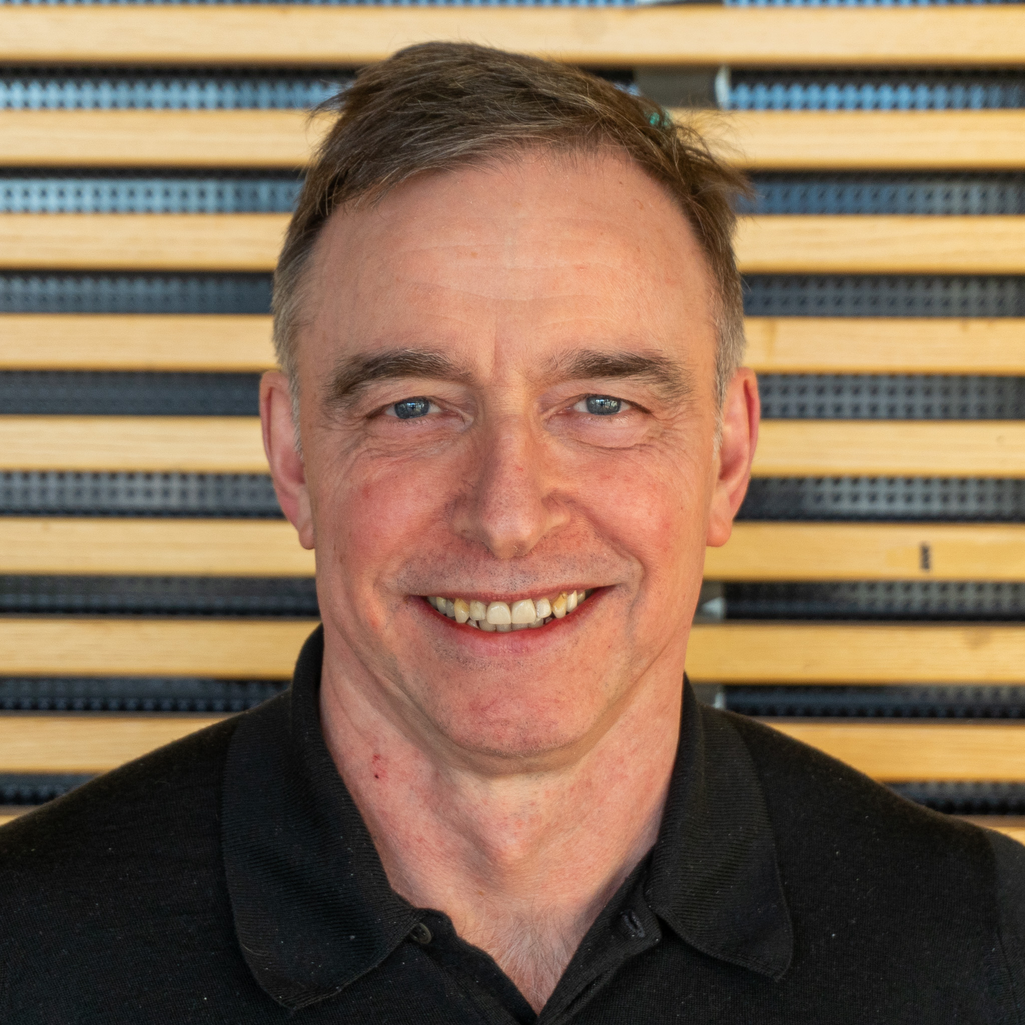 En mann som smiler til kameraet